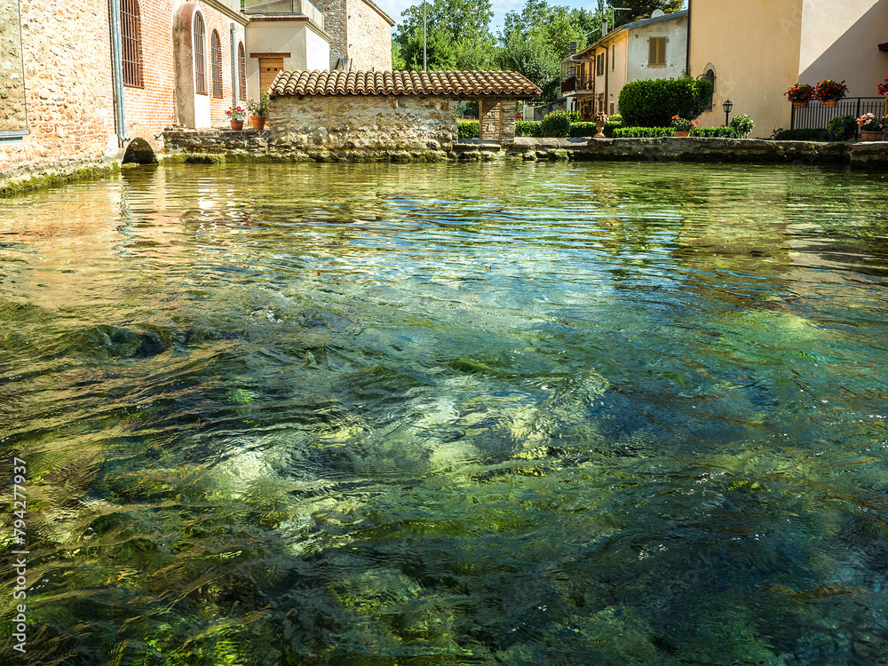 Naklejka premium Bagno Vignoni, a village nestled in the Val d'Orcia a few kilometres from Siena, where there is a large medieval stone pool where the water gushes out from the thermal spring