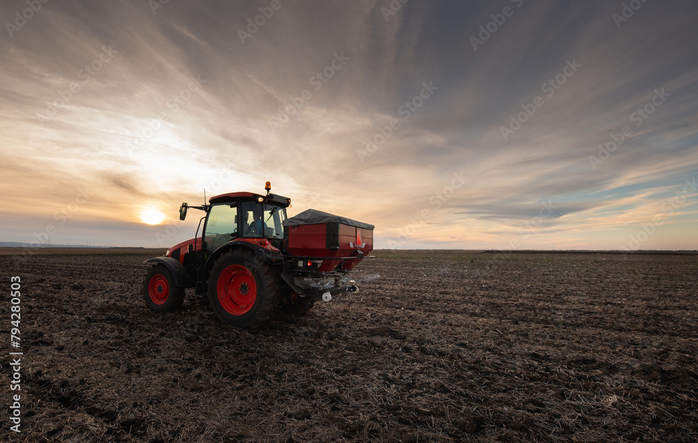 Farmer fertilizing arable land with nitrogen fertilizer