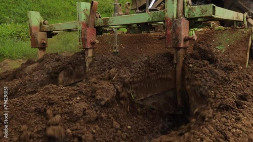 Wallpaper Mural A tractor cultivates land in the countryside. A tractor plows a field with a plow on a small farm. 4K video. Tiller for cultivating land close-up. Torontodigital.ca