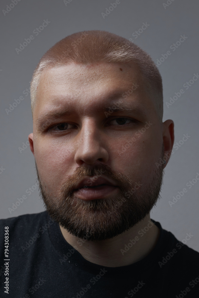 Portraits of a Millennial guy with a short haircut and beard, earrings in his ears Portraits of a Millennial guy with a short haircut and beard, earrings in his ears
