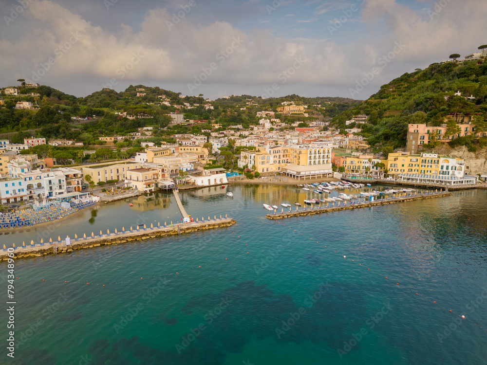 Fototapeta premium Vista aerea dell'alba del porto di Lacco Ameno ad Ischia. Roccia, mare, sole e mille colori