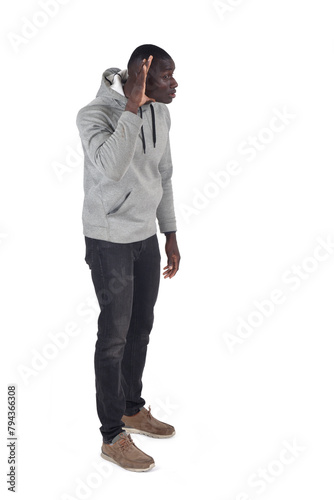 side view of a man with hand on ear who is listening on white background