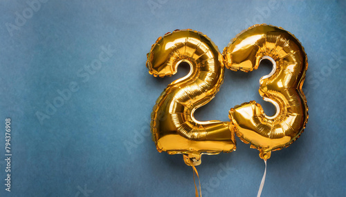 Banner with number 23 golden balloon. Twenty three years anniversary celebration. Blue background.