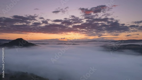 Sunrise aerial view hyperlapse video with mountains and cloudy color sky, and fog in Correze