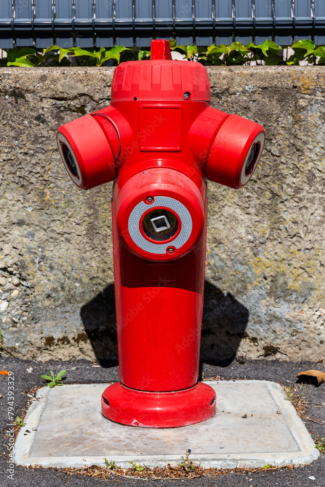 Fire hydrant in french street. Red triple fire hydrant on the street, close up face.