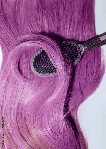 a comb lying on purple hair and wrapped in a strand of hair