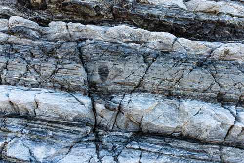 Nature force compressed cracked rock layers structure formation close-up details, in various shapes, colors, thicknesses, at south central coast of Crete, Greece. Nature and Geological science concept