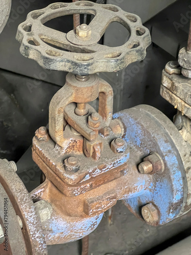 Old worn and rusty valve on the steam pipe in the boiler room