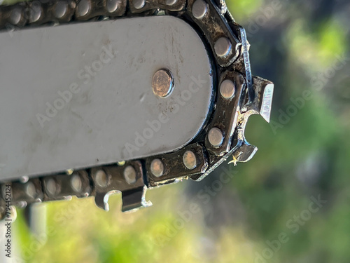 Close-up of a chain on the guide bar of a small wood chainsaw