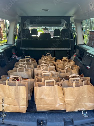 Packages with charity gifts for the elderly and those in need packed into the trunk of a car