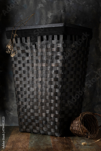 Large wicker basket near a gray plastered wall photo