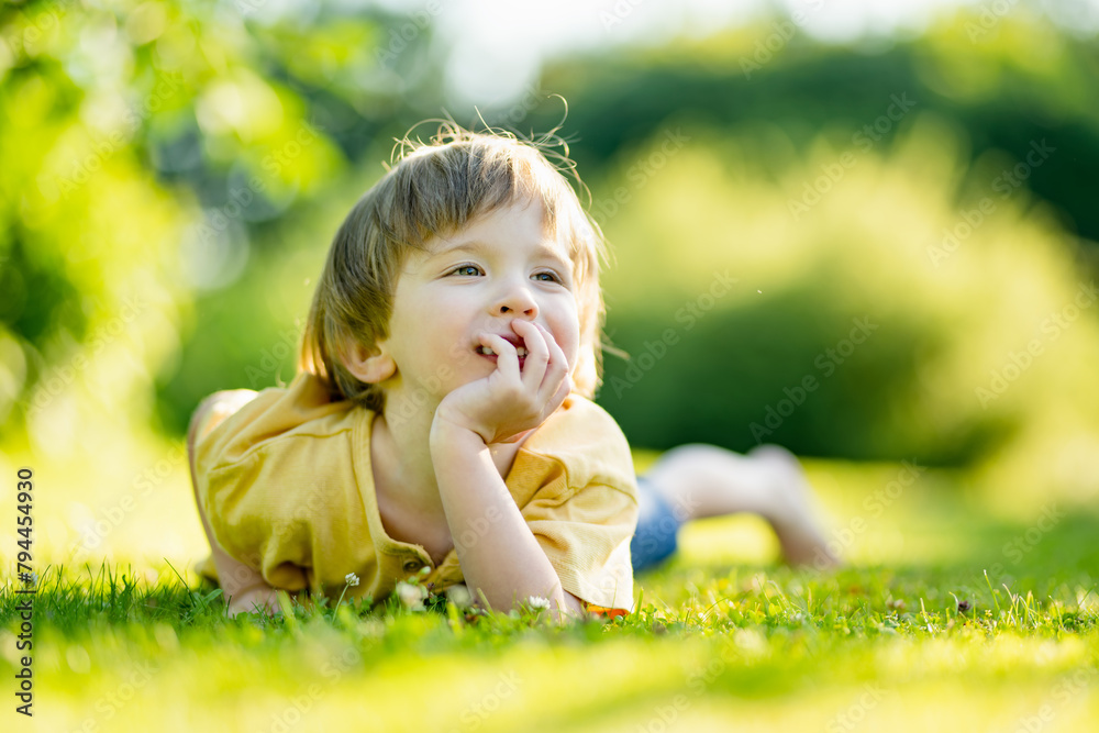 Adorable little boy having fun outdoors on sunny summer day. Kid running outdoors. Child exploring nature. Summer activities for small kids. Adorable little boy having fun outdoors on sunny summer day. Kid running outdoors. Child exploring nature. Summer activities for small kids.