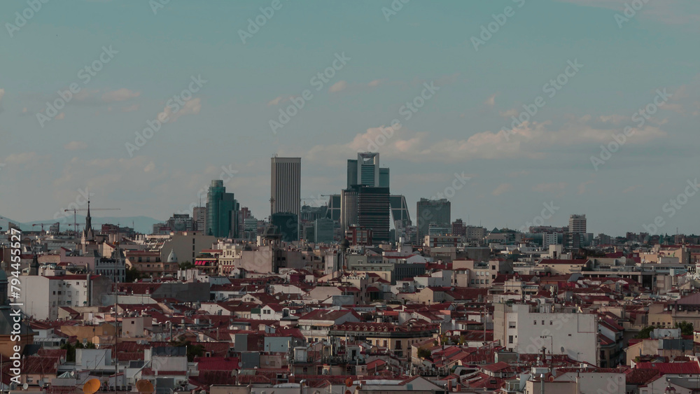 
Photograph of the 4 towers of Madrid in the distance with urban landscape and clear sky