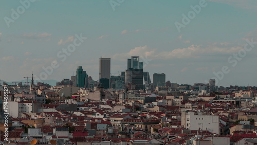 
Photograph of the 4 towers of Madrid in the distance with urban landscape and clear sky