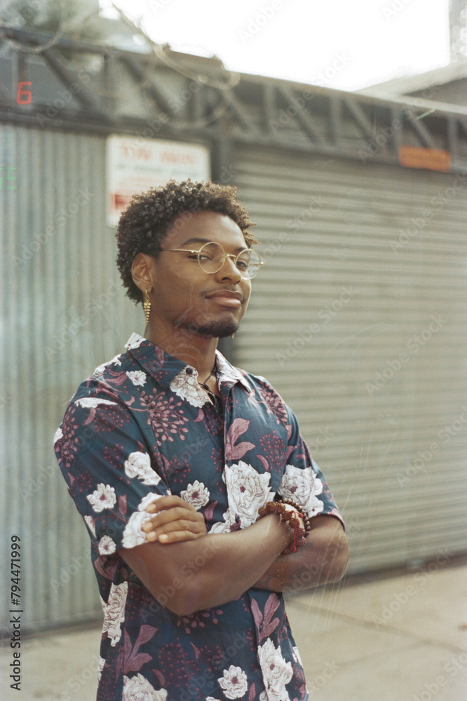 stylish young man looking sideways at camera with arms crossed stylish young man looking sideways at camera with arms crossed