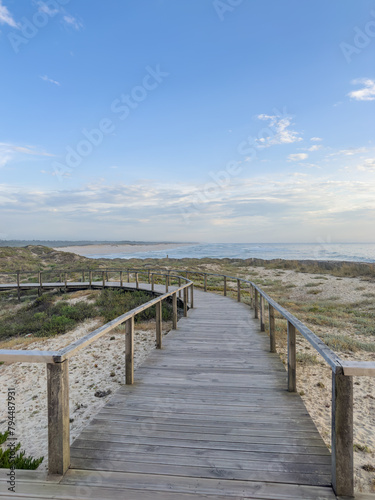 A wood pedestrian walkways, build over a sand dune that is used to give beach access in Furadouro beach, glows at sunset. Ovar, Aveiro, Portugal, Europe © anammarques