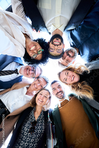 Fotografie Vertical low angle view of cheerful group of diverse business people in formal w