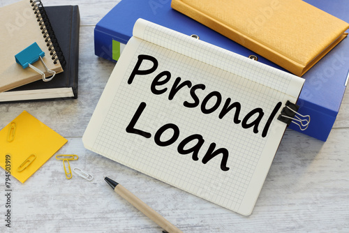 personal loan text on a notepad near a blue folder with a yellow notepad