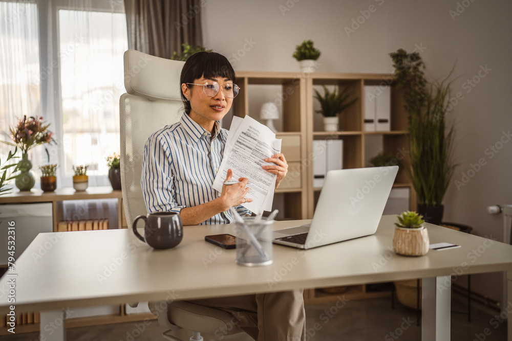 Mature japanese woman hold document and have consultation via video call Mature japanese woman hold document and have consultation via video call