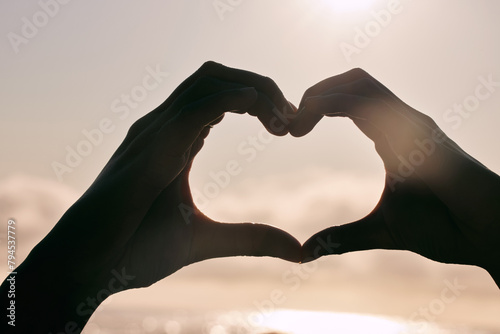 Silhouette, heart hands and couple at beach for sunset, love and bonding for care together on summer holiday. Shadow, closeup and romance at ocean sea for peace, support and emoji sign for connection
