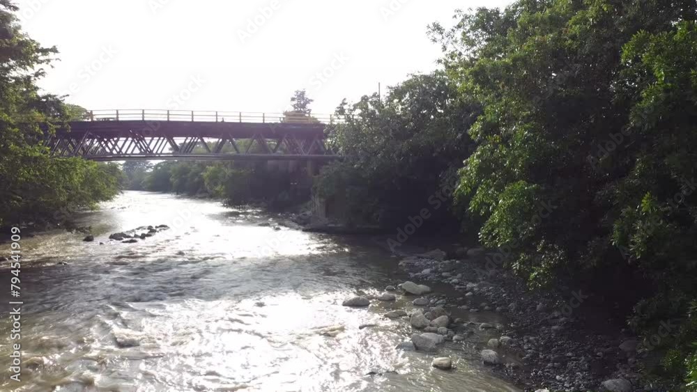 Beautiful highway surrounded by farms and green pastures. Nice river on the side of the road with trees and a large forest. Beautiful highway surrounded by farms and green pastures. Nice river on the side of the road with trees and a large forest.