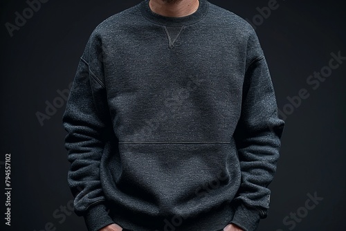A man in a grey sweatshirt has his hands in his pockets photo