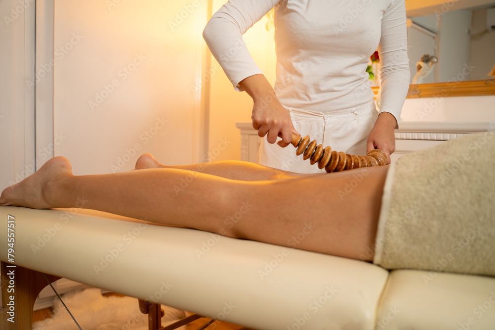 Madero anti cellulite massage with wooden tools, thigh massage - obrazy, fototapety, plakaty 