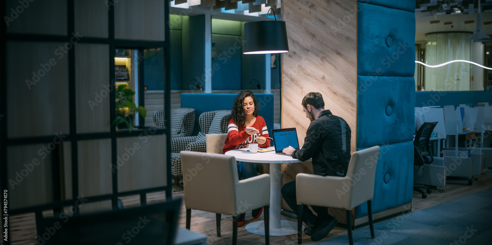 Man and woman work in coworking in the evening Man and woman work in coworking in the evening