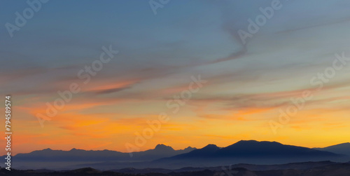 Luminoso tramonto arancio e ocra sopra le montagne italiane © GjGj