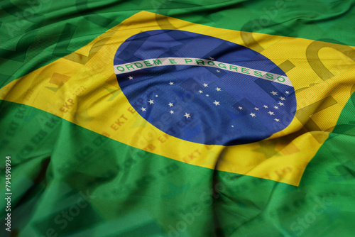 waving colorful national flag of brazil on a euro money banknotes background. finance concept. photo