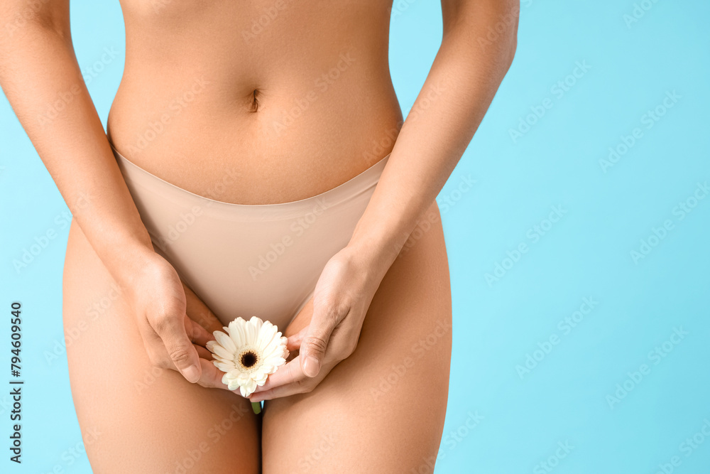 Beautiful young woman in panties with gerbera flower on blue background, closeup - obrazy, fototapety, plakaty 