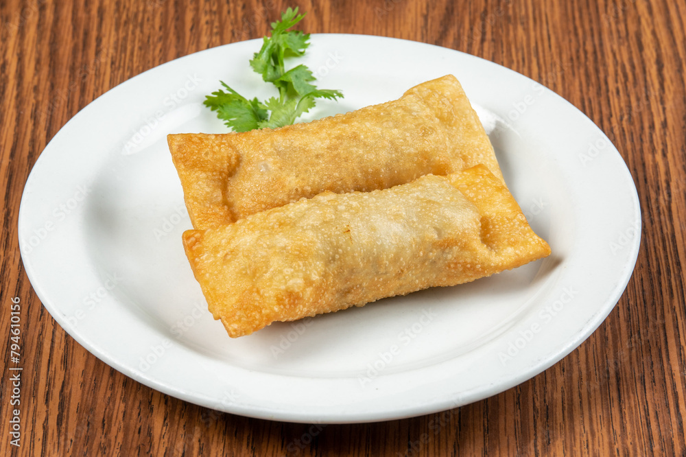Chinese or asian chrispy wonton egg rolls on a white plate Chinese or asian chrispy wonton egg rolls on a white plate