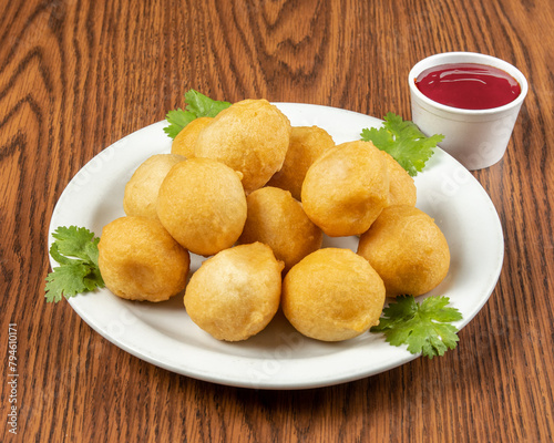 A plate of Chinese sweet and sour chicken balls with sauce