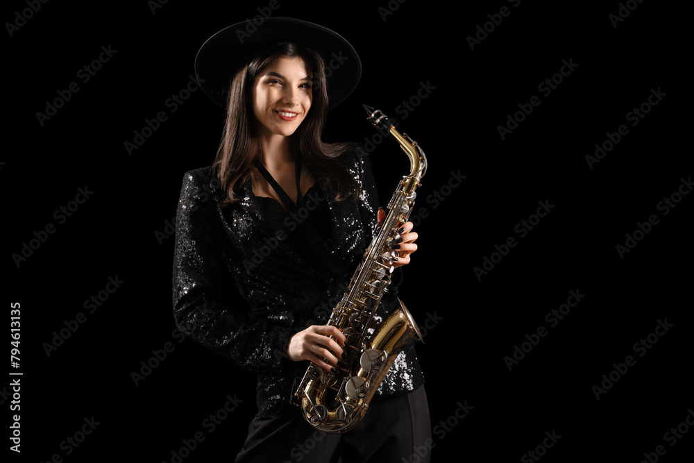 Beautiful young woman with saxophone on dark background Beautiful young woman with saxophone on dark background