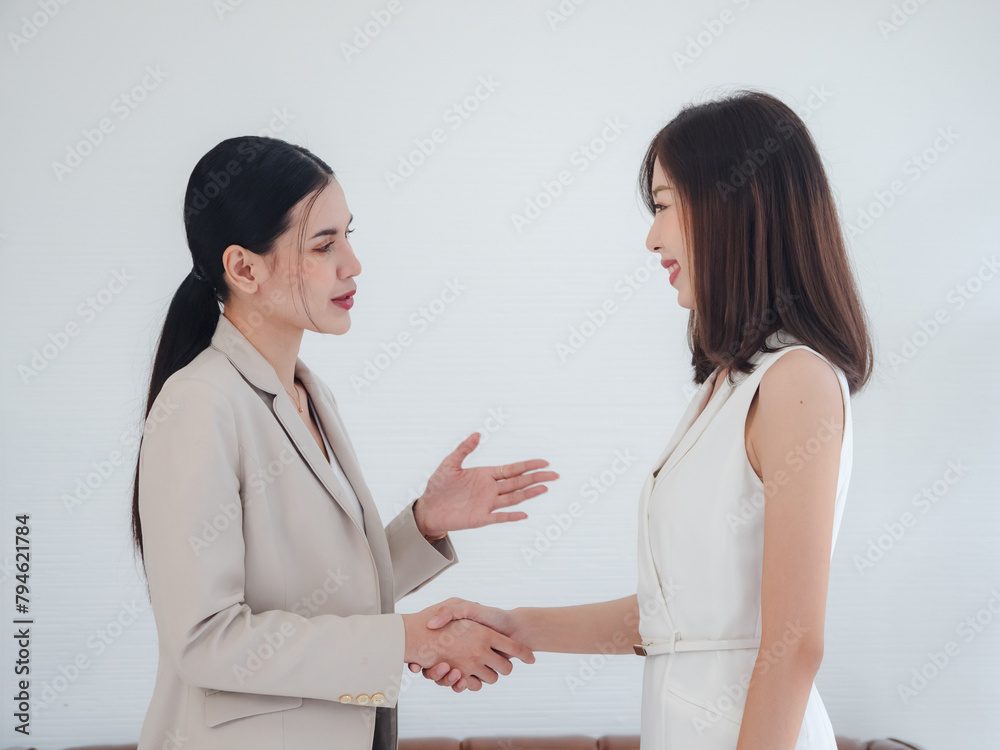 Portrait business teamwork woman two person asian standing on wall white board looking smile shake hand within the agreement plan new job project ready for happy working online sale inside room office Portrait business teamwork woman two person asian standing on wall white board looking smile shake hand within the agreement plan new job project ready for happy working online sale inside room office