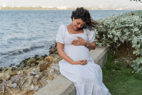 Expectant Mother Cradling Belly by Seaside