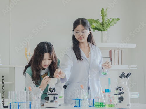 Portrait child kid girl asian young student twoperson team group learning and smile have fun enjoy happy with science lab technology with in  classroom has tubetest Microscope chemicals on table photo