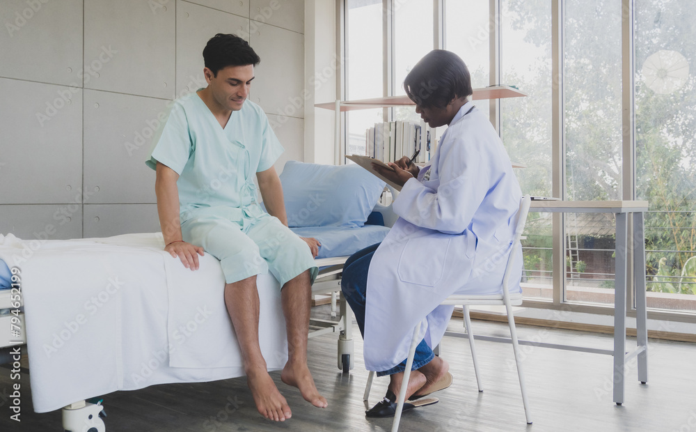 Fototapeta premium Portrait patient caucasian man with woman doctor nurse carer physical therapist black people two person sitting talk help support give advice and holding document . check relax inside room hospital