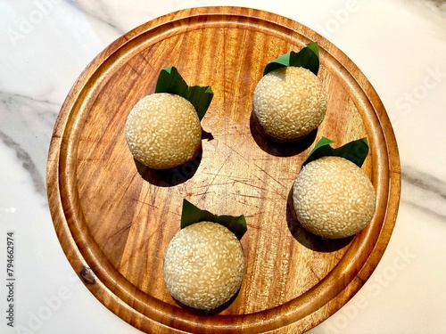 Traditional Indonesian snack called Onde-onde served on a wooden plate on a table