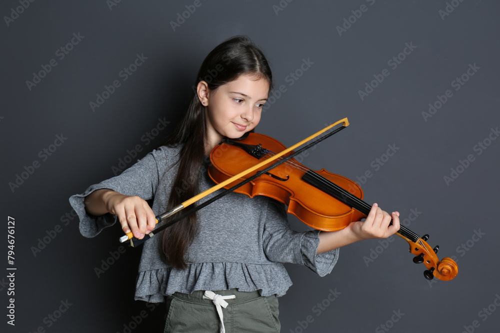 Preteen girl playing violin on black background Preteen girl playing violin on black background