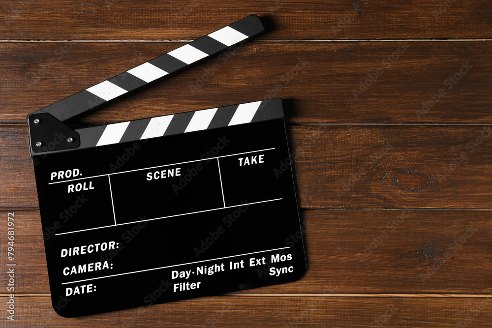Clapperboard on wooden table, top view. Space for text