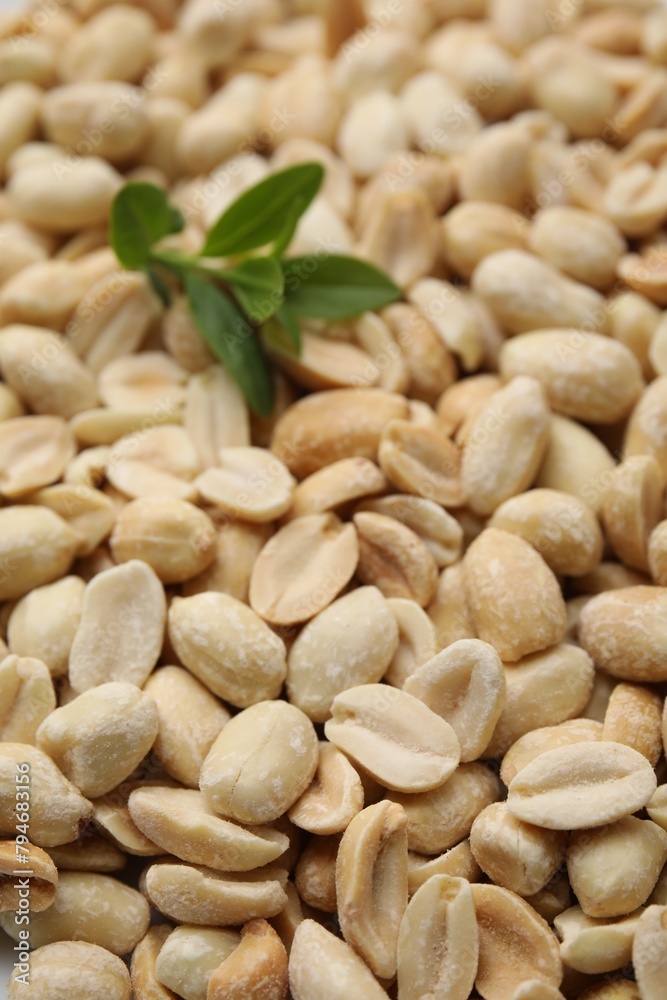 Many fresh peeled peanuts and leaves as background, closeup