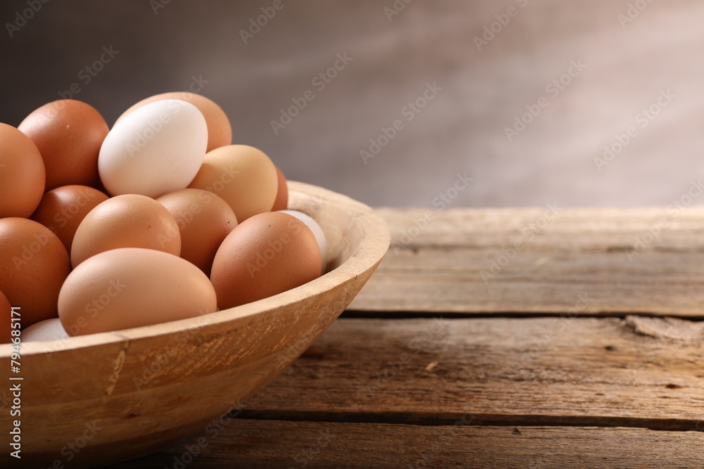 Chicken eggs in bowl on wooden table, closeup. Space for text Chicken eggs in bowl on wooden table, closeup. Space for text