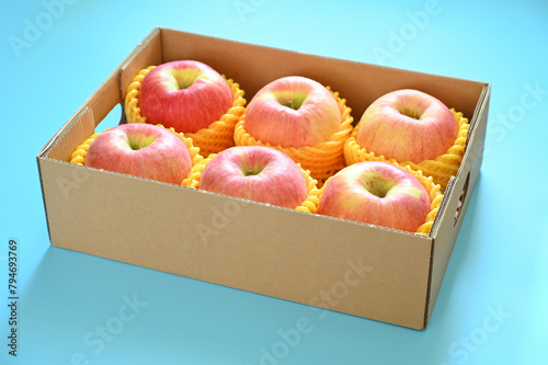 beautiful pink apple in the box on blue background