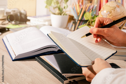The educational concept: a hand is writing with a pen on a notebook