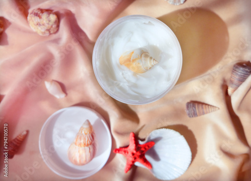White  jar with skincare product. Summer decorations  with  seashell around cosmetology bottle.  Wellness  mockup and beauty concept.