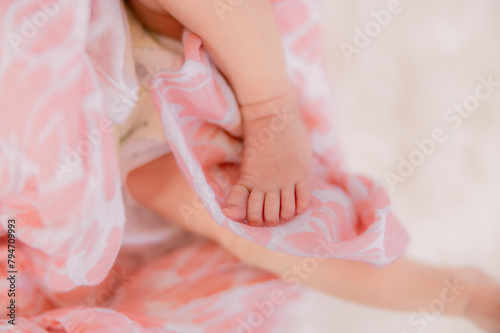 Tiny baby feet wrapped up in a pink blanket.