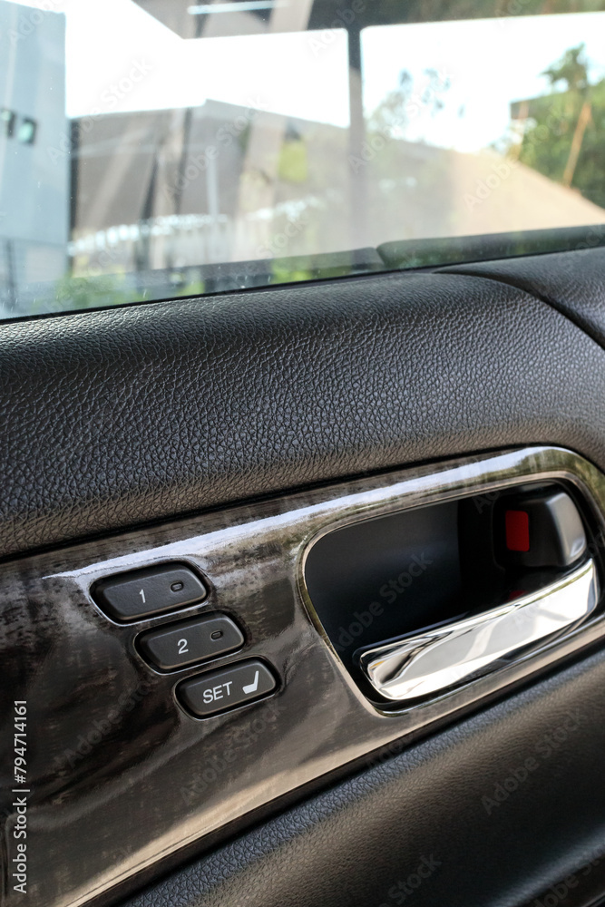 seat control buttons and car door opener in modern car, shallow depth of field