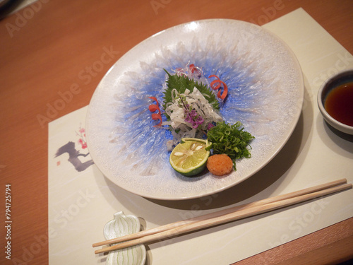 Plate of fugusashi or Japanese fugu blowfish sashimi thin transparent slices photo