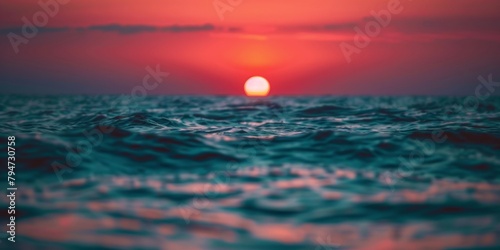 Sunset over a calm ocean horizon with vibrant colors and ripples.